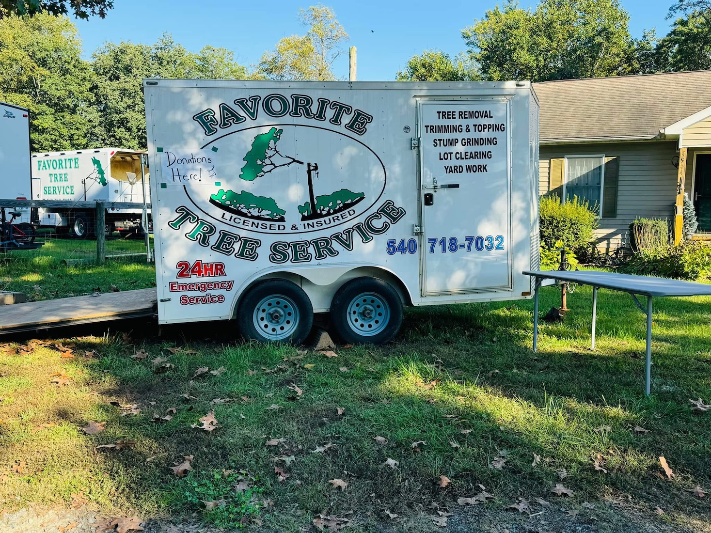 Favorite Tree Service branded trailer staged at a pruning job